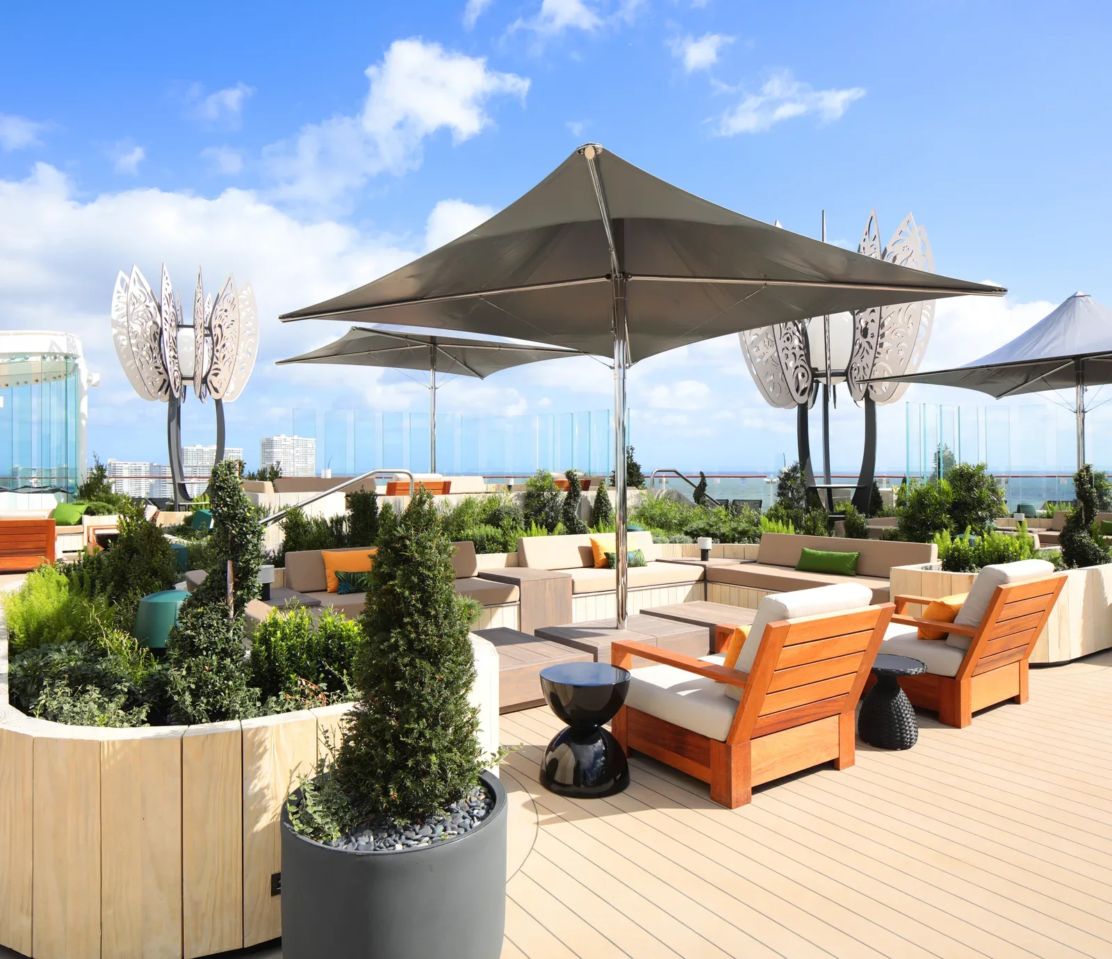 Celebrity Cruises Rooftop Garden outdoor deck with lounge seating, tropical plants, and ocean views